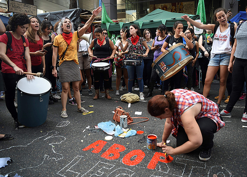 Una manifestante hace una pintada en el suelo de la calle para pedir el acceso de las mujeres a un aborto seguro, libre y legal durante una concentración frente al Congreso Nacional de Buenos Aires, 10 de abril de 2018