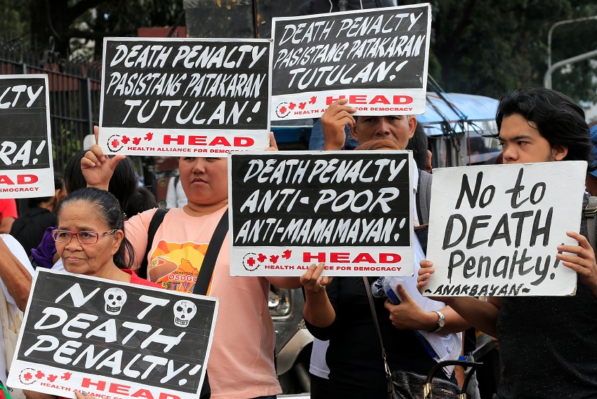 Activistas sostienen pancartas durante una manifestación de protesta contra la aprobación del proyecto de ley de pena de muerte, en la puerta de la Cámara de Representantes en la ciudad de Quezon, en Manila, Filipinas