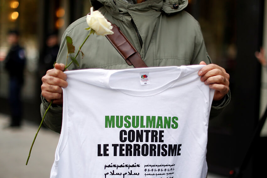 Un hombre porta una camiseta con el lema "Musulmanes contra el terrorismo" en la entrada de Bataclán, París