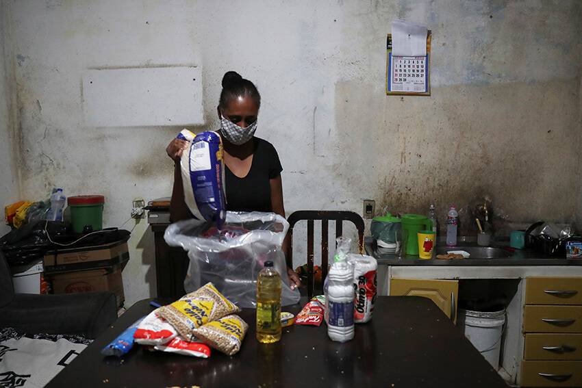 Miriam dos Anjos desempaqueta l'ajuda alimentària rebuda de Central Unica das Favelas 