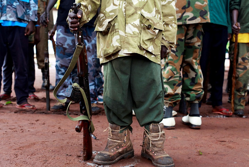 Un ex niño-soldado sostiene un arma durante la ceremonia de liberación de niños soldados, en las afueras de Yambio, Sudán del Sur