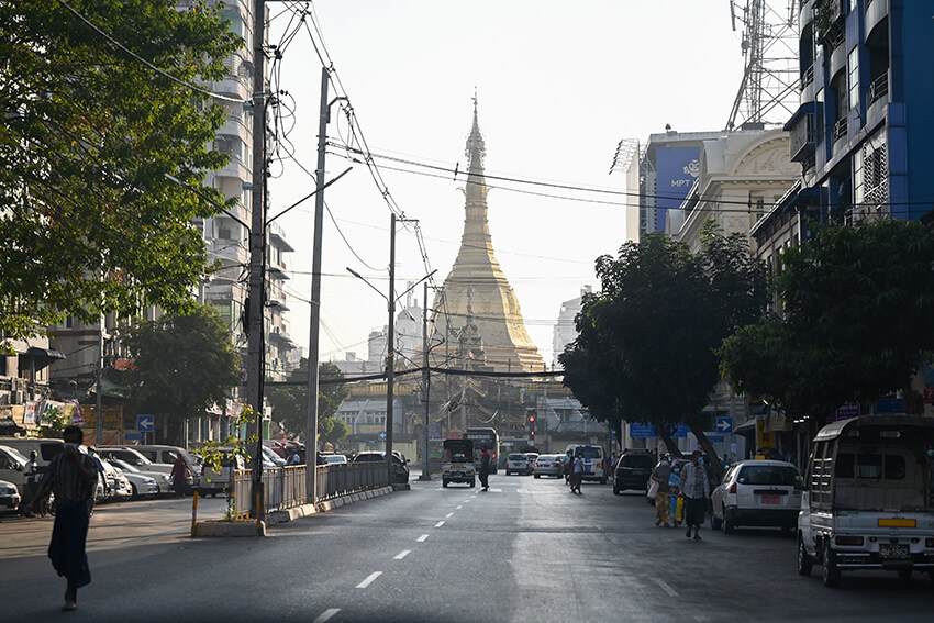 La gente camina junto a la Pagoda Shwedagon en una carretera vacía en Yangon el 1 de febrero de 2021, el día en que el ejército de Myanmar dio el golpe de Estado. 