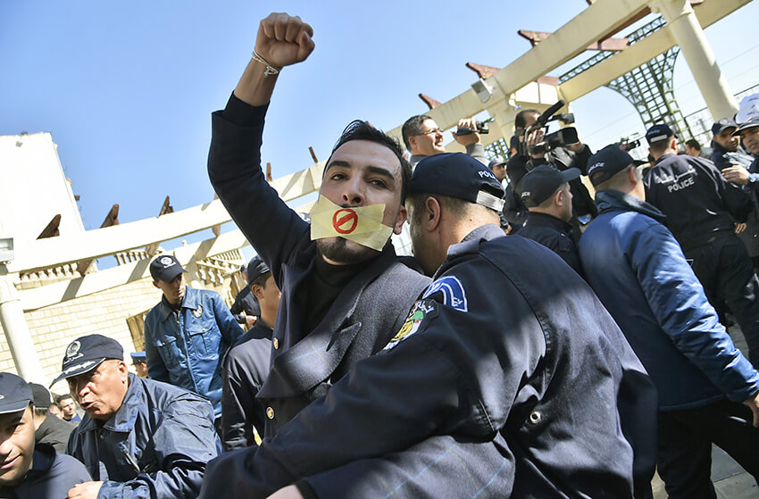 Un policía argelino sujeta a un manifestante que participa en una concentración organizada por periodistas contra la supuesta censura a la hora de cubrir las protestas contra un quinto mandato del presidente Abdelaziz Buteflika, 28 de febrero de 2019.