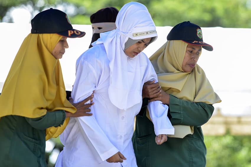 Mujer musulmana escoltada por la policía para ser azotada en público
