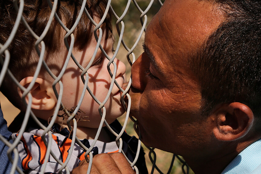 Un refugiado sirio besa a uno de sus hijos
