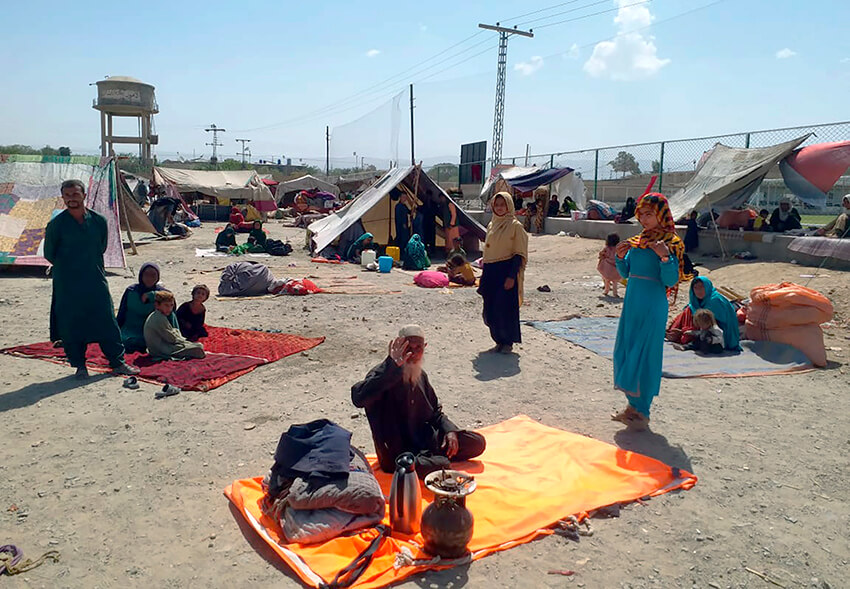 Familias afganas sentadas fuera de sus tiendas en un área abierta en las afueras de Chaman, una ciudad fronteriza en la provincia suroccidental de Baluchistán, el 1 de septiembre de 2021. Decenas de familias afganas han cruzado a Pakistán a través de la frontera suroccidental de Chaman, un día después de que Estados Unidos pusiera fin a su presencia militar en Afganistán.