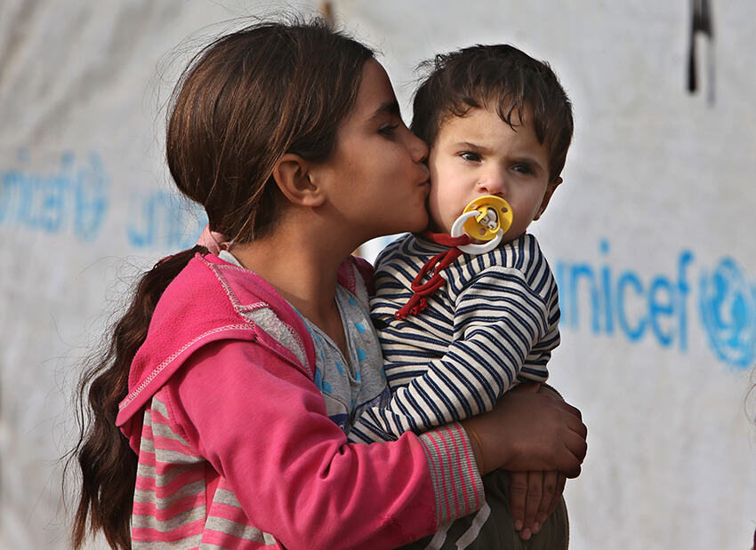 Una niña siria desplazada besa a su hermano menor en uno de los campos de refugiados sirios al este del Líbano. En el Día Internacional del Beso, Amnistía recuerda la necesidad de respetar los derechos humanos de las personas refugiadas