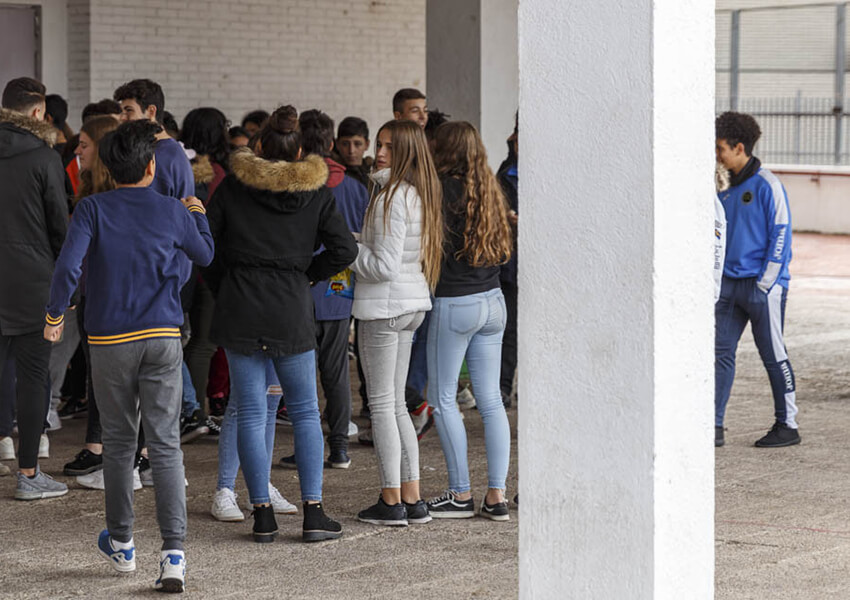 Chicos y chicas jóvenes esperando para entrar en clase