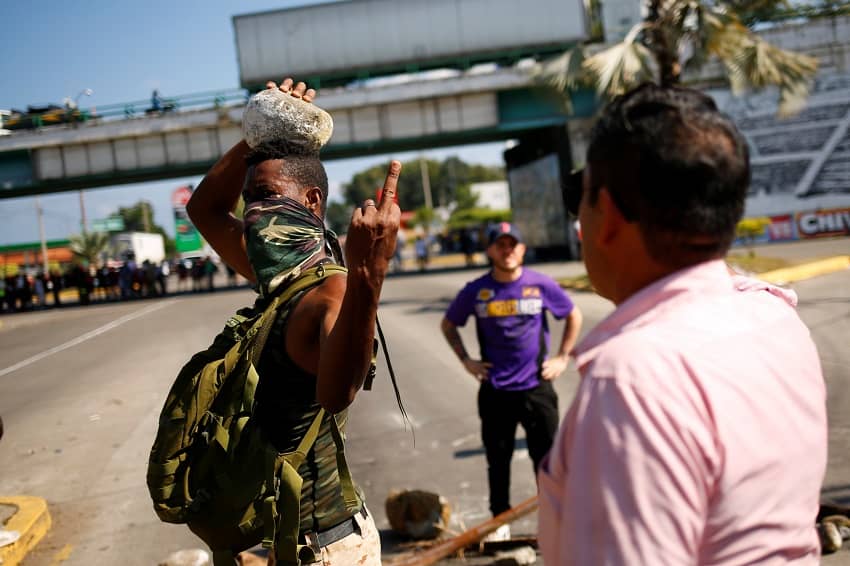 Un migrante haitiano durante una protesta en México hace un gesto a un conductor enfadado