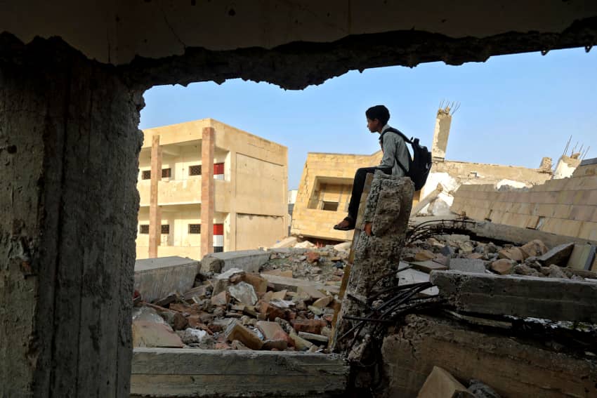 Un estudiante yemení contempla el reconto escolar derruido el primer día del curso académico
