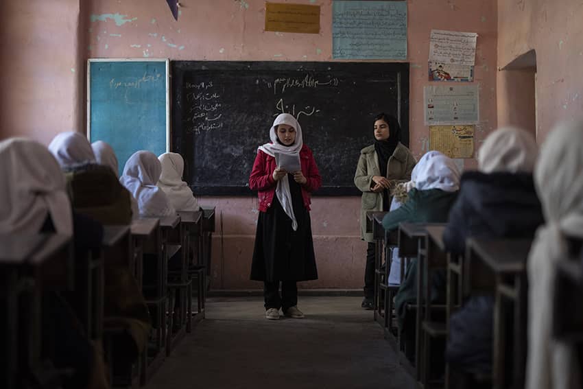 Una estudiante afgana lee un texto frente a sus compañeras