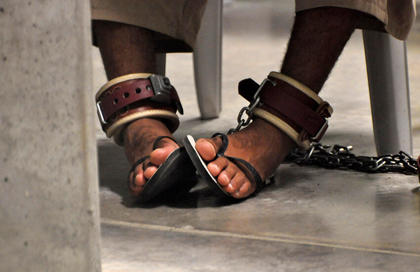 se ven los pies de un detenido de Guantánamo encadenados al suelo