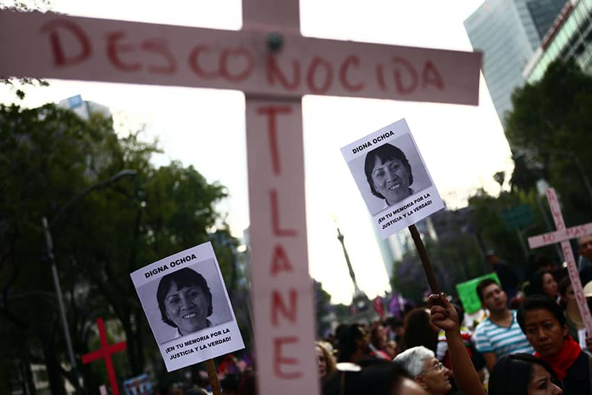 carteles con la leyenda "Digna Ochoa. En tu memoria por la justicia y la verdad" se ven durante una manifestación para exigir justicia para las mujeres víctimas de la violencia