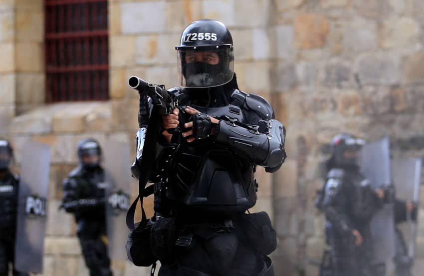 Policía antidisturbios con su pistola de gases lacrimógenes. ¿Qué tienen que ver estas armas menos letales con la tortura?