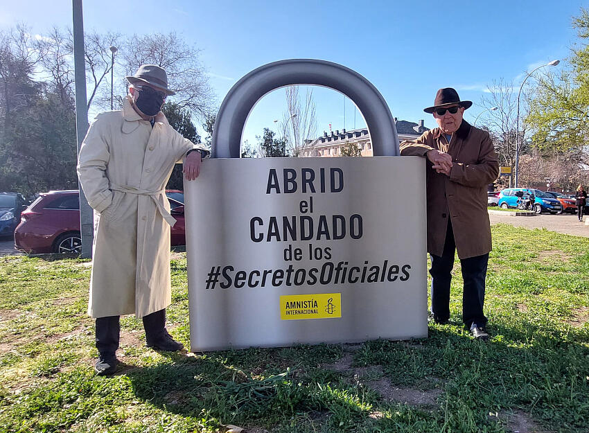 Activistas de Amnistía Internacional posan junto a un candado gigante frente a La Moncloa para pedir al gobierno una Ley de Secretos Oficiales que no permita “esconder bajo llave” ataques a los derechos humanos