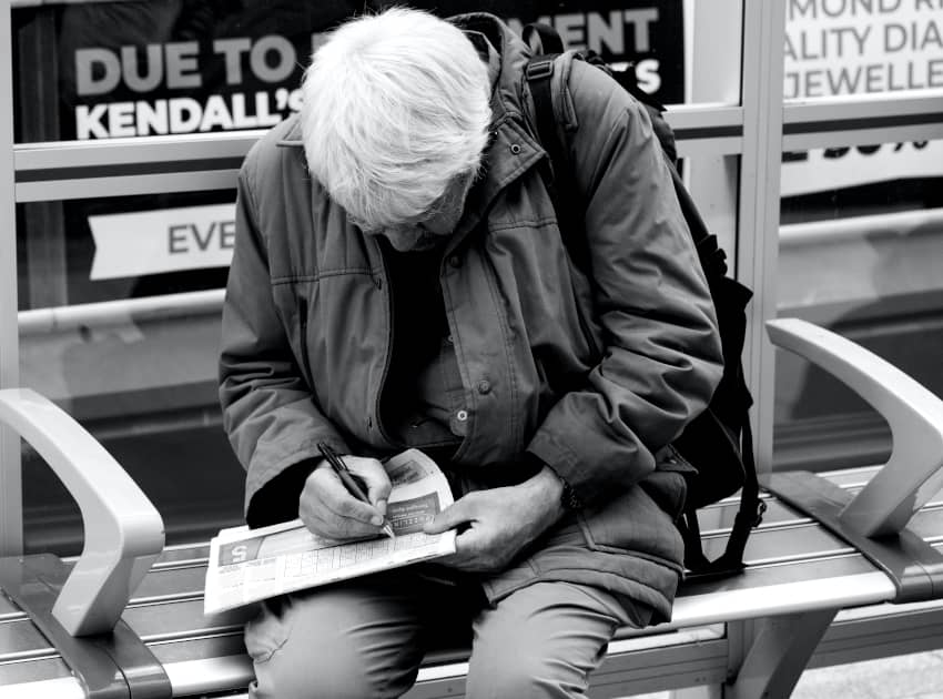 Una persona mayor escribe una nota. Invertir en Alfabetización: Un compromiso global en su día internacional