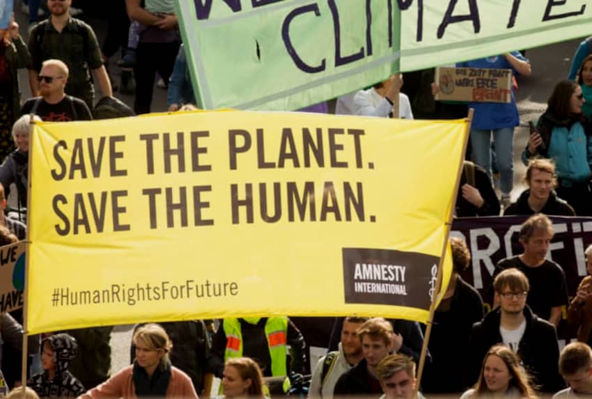 Lona que pone "Salva el planeta, salva la humanidad". Debatiendo el cambio climático en la COP28