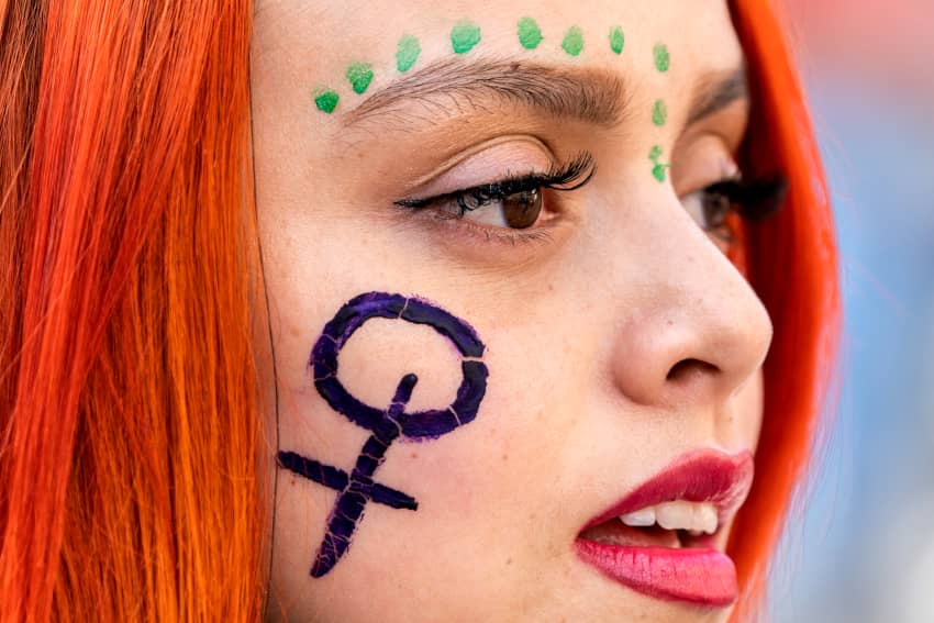 Una mujer con un símbolo femenino en la cara asiste a una manifestación a favor de la igualdad de género. Amnistía Internacional denuncia en su informe anual la grave situación de discriminación que padecen millones de mujeres y niñas en todo el mundo.