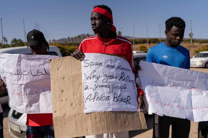 Un manifestante sostiene un cartel en el que se lee "España y Marruecos, ¿por qué matáis a los jóvenes. África Negra" frente al centro de acogida de inmigrantes CETI de Melilla. En este enclave se produjo una masacre