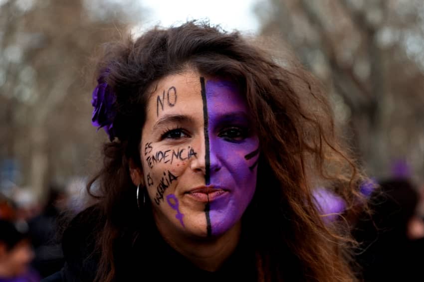 Una mujer con la cara pintada con la leyenda "No es una moda, es una urgencia" participa en una protesta con motivo del Día Internacional de la Mujer en Madrid, España, 8 de marzo de 2022