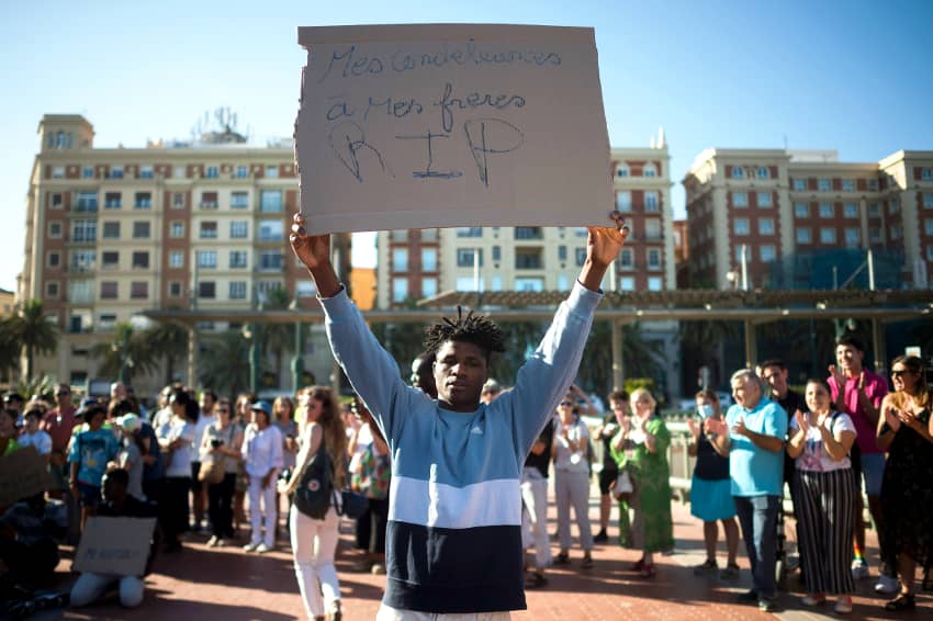 Un manifestante sostiene una pancarta durante una manifestación en solidaridad con las personas migrantes
