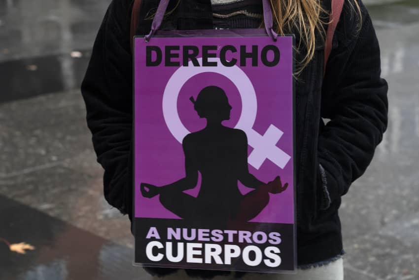 Una joven con una pancarta con el lema «derecho a nuestros cuerpos»