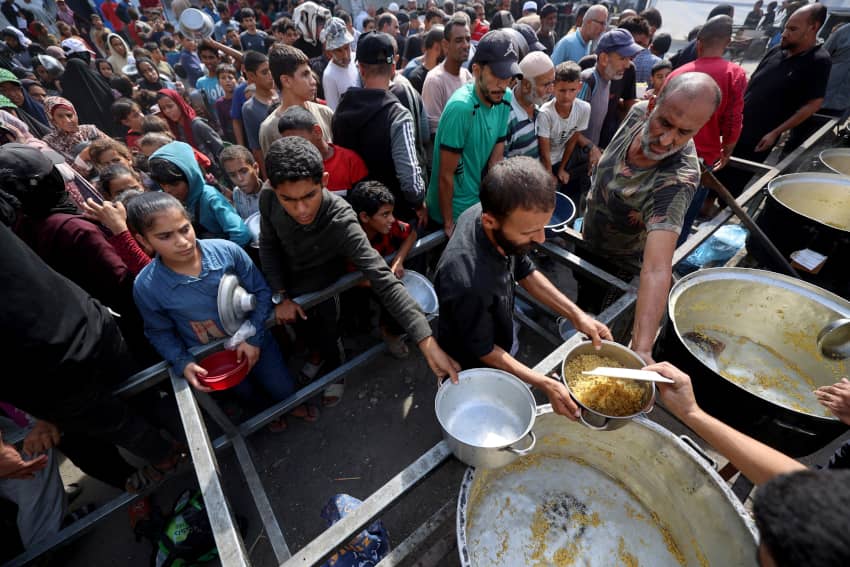 Personas palestinas hacen fila para recibir alimentos en un refugio de Nuseirat, Gaza, noviembre de 2025.
