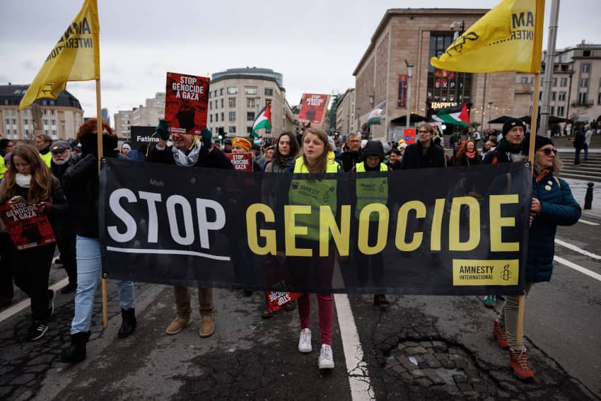 Activistas de Amnistía Internacional en Bruselas muestran una pancarta de “Stop genocide”