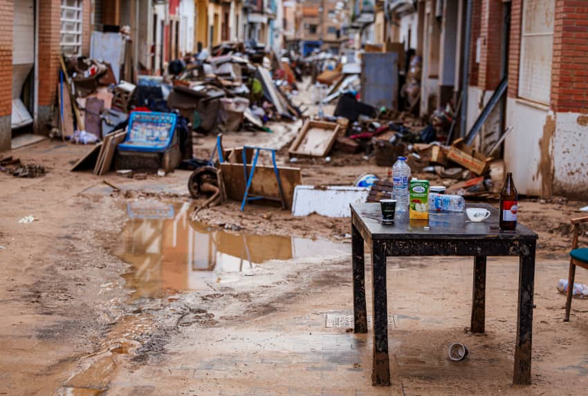 Calle de Catarroja con muebles y barro tras las inundaciones de la DANA, símbolo de la falta de información clara sobre los daños reales.