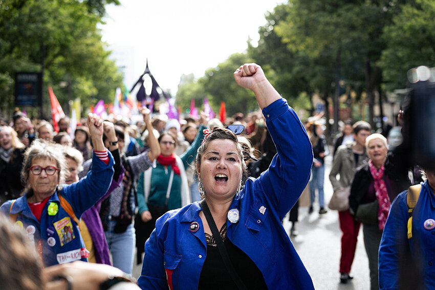 Activista levantando el puño en una marcha por los derechos de las mujeres y el acceso al aborto.