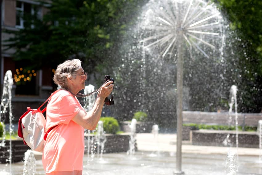 Persona mayor junto a una fuente de agua durante una ola de calor con altas temperaturas.