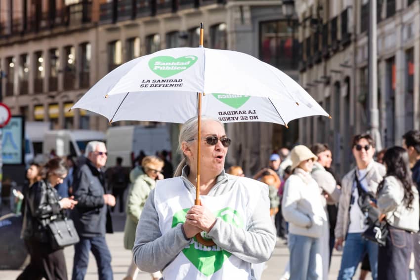 Una manifestante sostiene un paraguas, durante una protesta por la sanidad pública en el centro de Madrid.