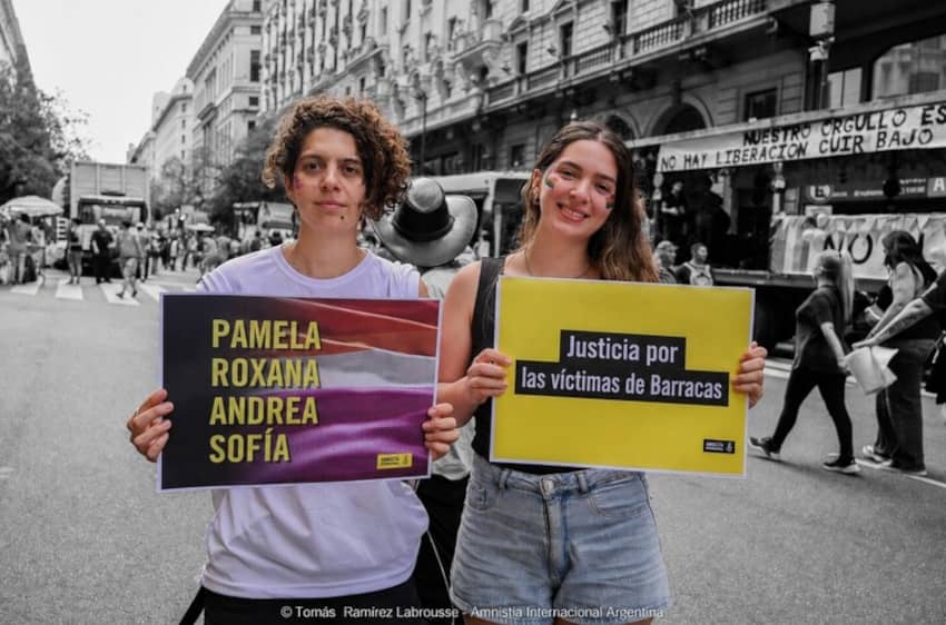 Activistas sostienen carteles reclamando justicia para las víctimas del crimen de Barracas durante una movilización en Buenos Aires.