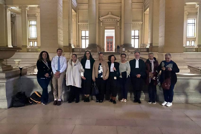 Personas afectadas por la segregación racial durante el periodo colonial belga y sus representantes ante el Palacio de Justicia de Bruselas.