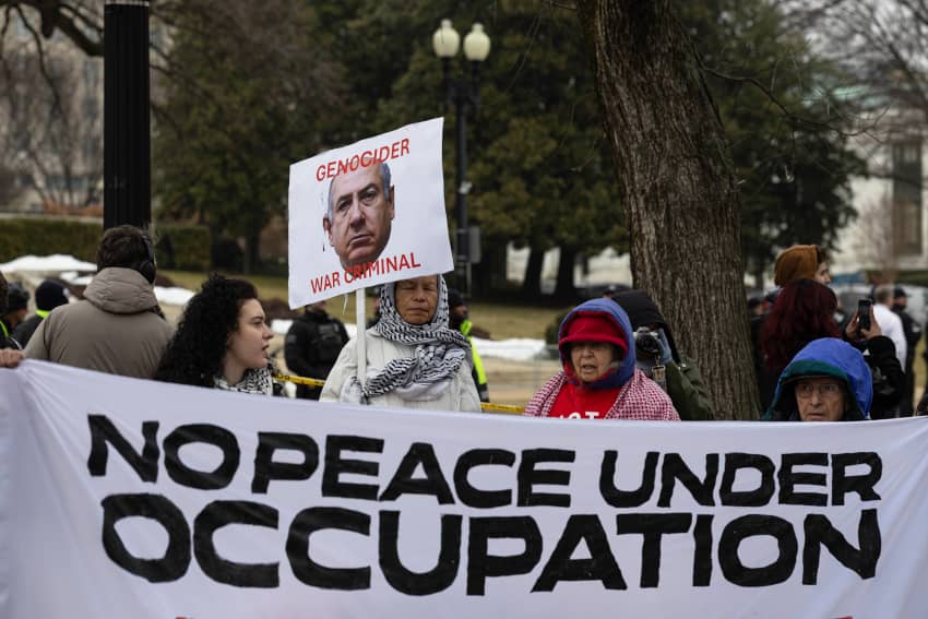Manifestantes pro palestinos y críticos con Donald Trump sostienen una pancarta que dice “No peace under occupation” frente al Instituto Donald J. Trump de la Paz en Washington, D.C.
