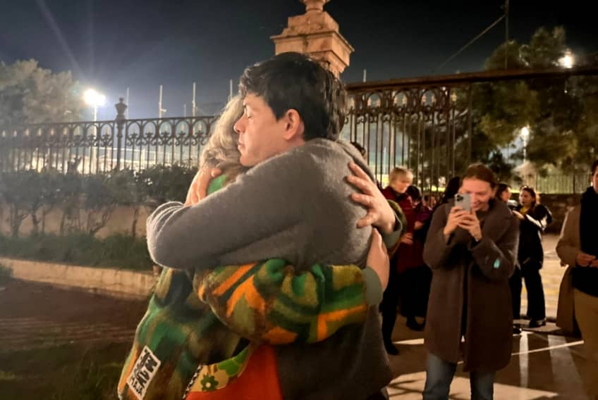 Seán Binder abraza a una persona tras conocerse su absolución después de años de proceso judicial en Grecia.