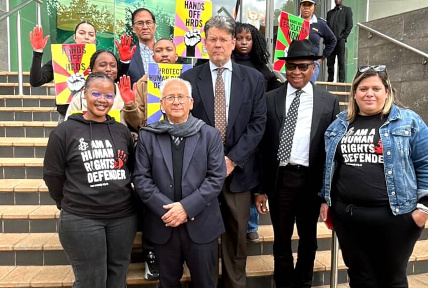 Defensores y defensoras de derechos humanos junto a representantes del gobierno sudafricano durante una campaña de protección a activistas.