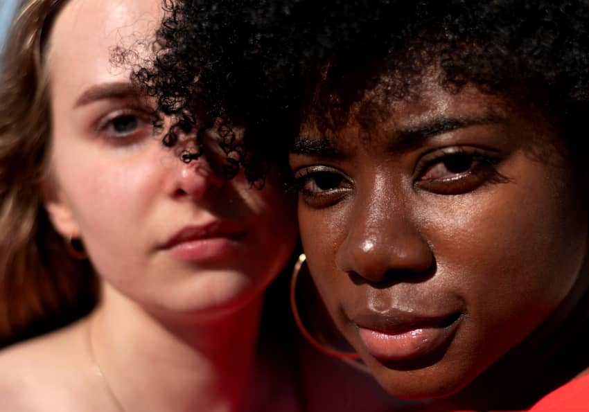 Retrato de dos jóvenes mujeres de distintas etnias mirando a cámara con expresión seria