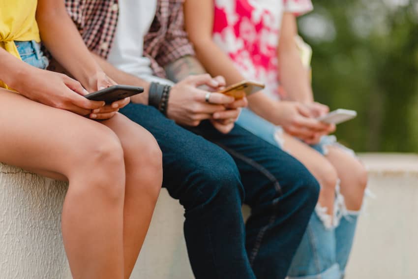 Adolescentes utilizan teléfonos móviles en un espacio al aire libre