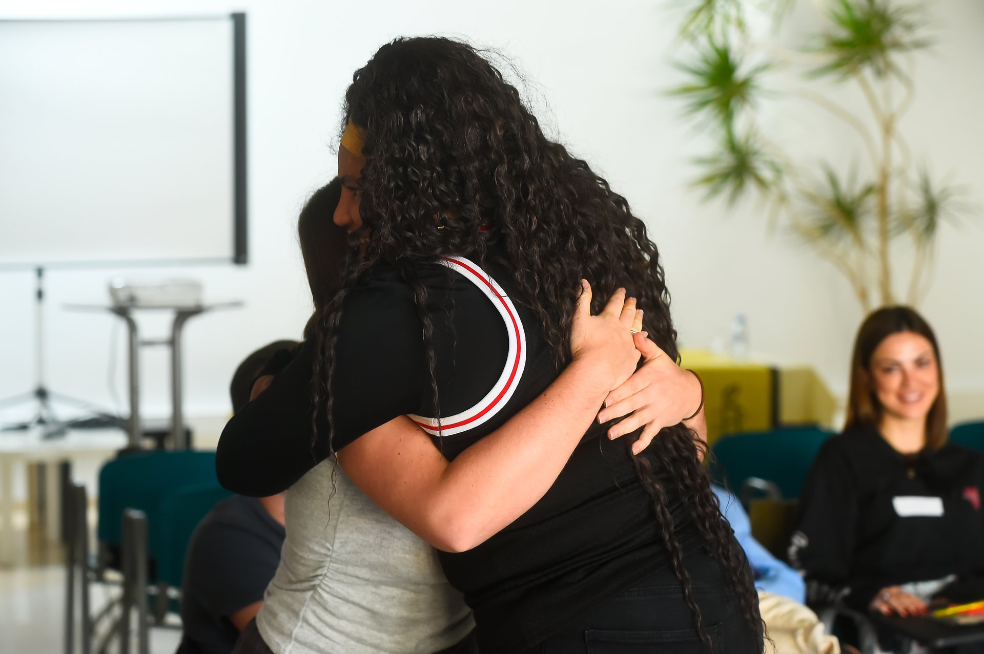 Dos personas se abrazan durante un taller de activismo.
