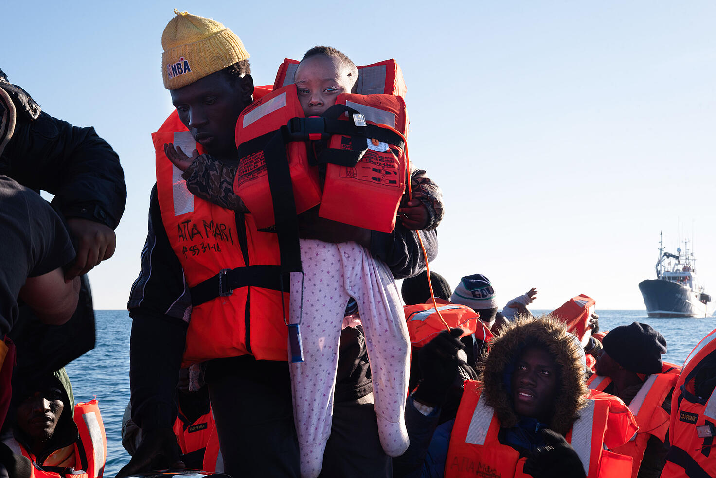 Un hombre sostiene a un bebé de 7 meses en el barco de rescate Aita Mari, tras el rescate de 40 personas en una zona cercana a la isla de Lampedusa...